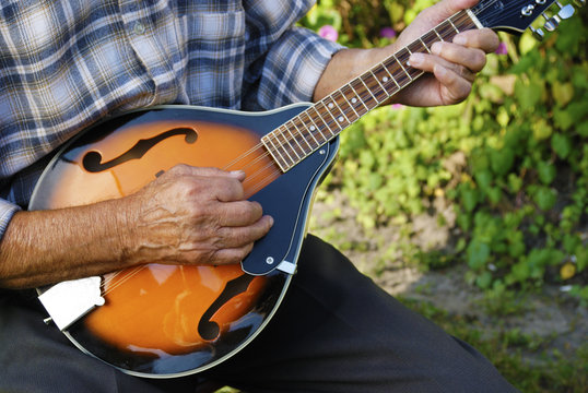 Senior man playing mandolin