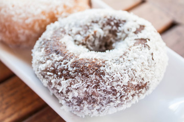 Close up chocolate coconut donut on white plate