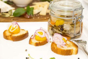 pickled herring in a glass jar with potato canapes