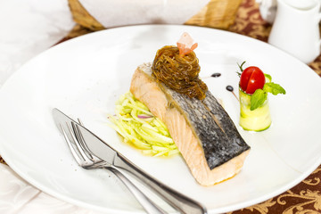 Baked salmon fillet with vegetables in a restaurant