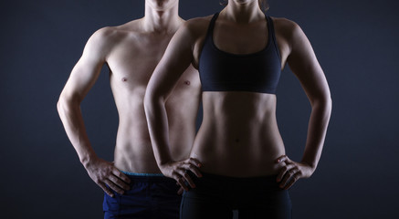 Strong man and a woman posing on a black background - 55141937