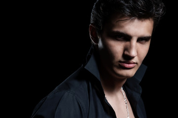 Portrait of a young handsome man on black background