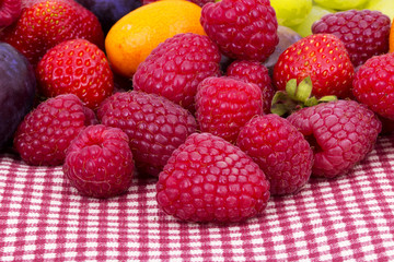 tasty summer fruits on a red tablecloth