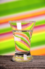 A glass of clear liquid on a bright background