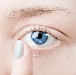Close up of inserting a contact lens in female eye