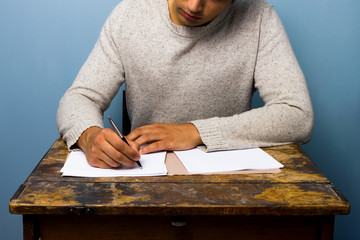 Young man writing at desk