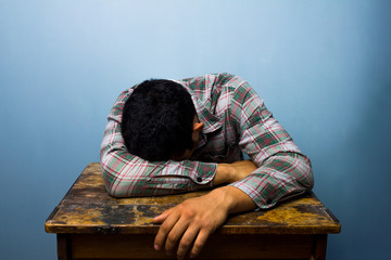 Young man sleeping at desk