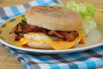 English muffin with fried egg, bacon and cheese