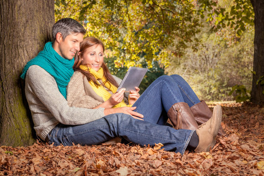 autumn couple with tablet online