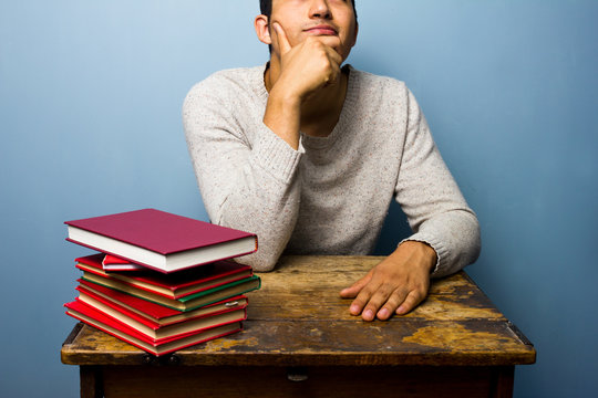 Student with books is thinking