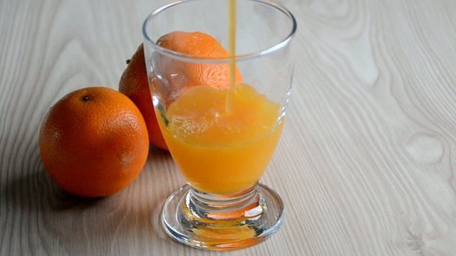 Llenando un vaso de zumo de naranja