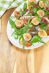 Fig ,Prosciutto and arugula salad. Copy space composition.