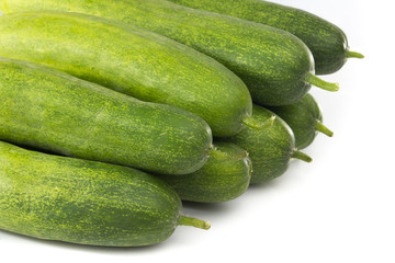 Fresh green cucumbers on white