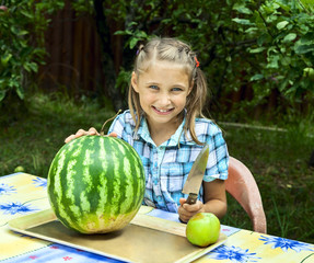 Fototapeta premium Young girl cut ripe watermelon