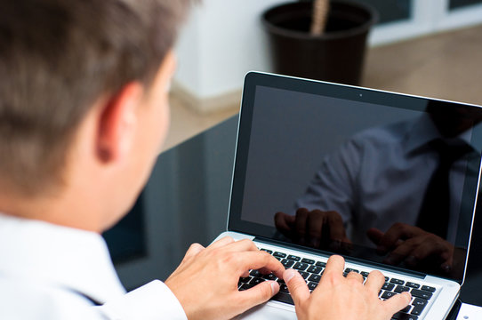 Gesch&auml;tsmann arbeitet an einem Laptop