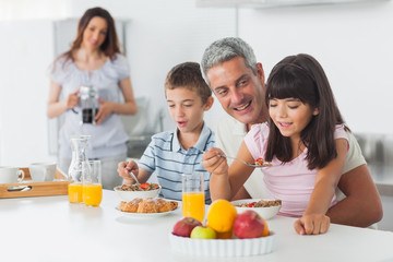 Obraz na płótnie Canvas Happy family eating breakfast in kitchen together