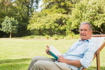 Happy mature man holding book