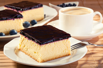 Cheesecake with blueberries and a cap of coffee