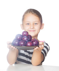 girl holding a bowl of plums