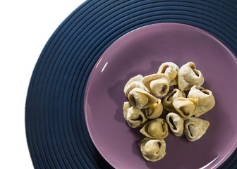Tortelli crudi su piatto con farina