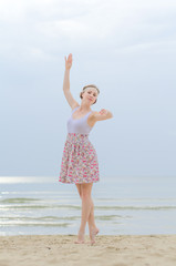 Young woman doing dancing elements near the sea