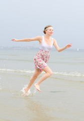 Young pretty woman running in the sea