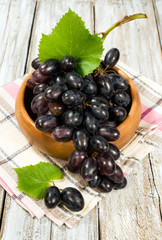 red ripe grapes in a wooden bowl