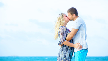 Fototapeta na wymiar couple in casual clothing kissing on the beach