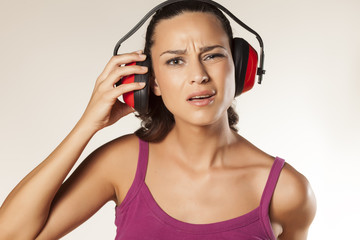 Naklejka premium young brunette can not hear because of the anti loud headset