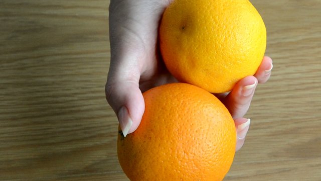 Chica mostrando dos naranjas en sus manos
