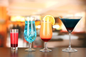 Several glasses of different drinks on bright background