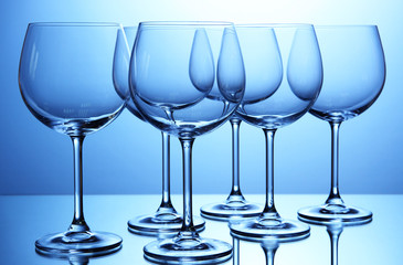 Empty wine glasses arranged on blue background