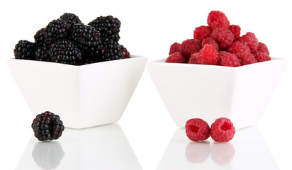 Ripe raspberries and blackberries in bowl isolated on white