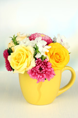 Beautiful bouquet of bright flowers in color mug,