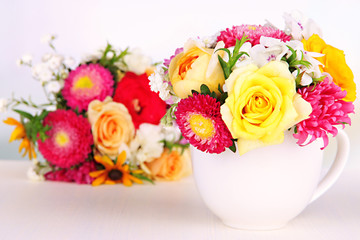 Beautiful bouquet of bright flowers in color mug,