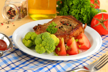 Piece of fried meat on plate on wooden table close-up