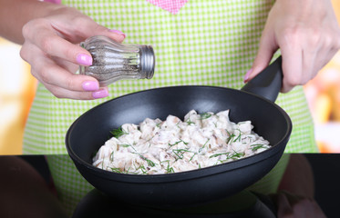 Hands cooking mushroom sauce in pan in kitchen