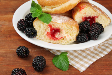 Tasty donuts with berries on wooden table