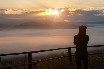 Silhouette of woman standing in sunrise