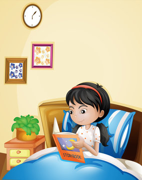 A young lady reading a storybook in her bed