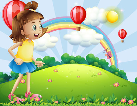 A young girl at the hilltop watching the floating balloons