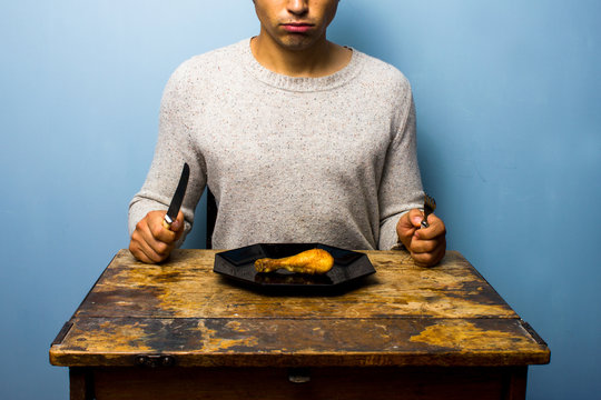 Young Man Having A Chicken Drumstick To Eat