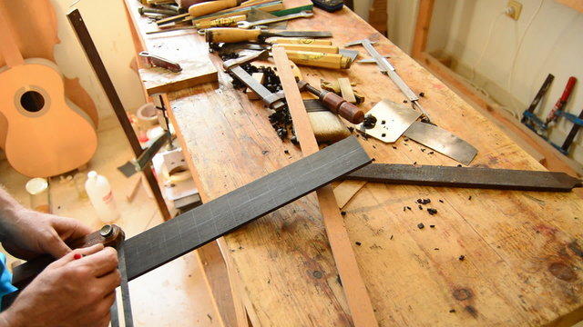 Luthier marking the frets of a guitar
