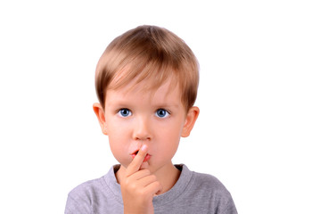 boy covers up his mouth with finger