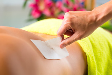 Man in Spa getting back waxed for hair removal