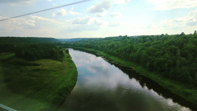 High-speed train goes on the bridge over the river (POV)
