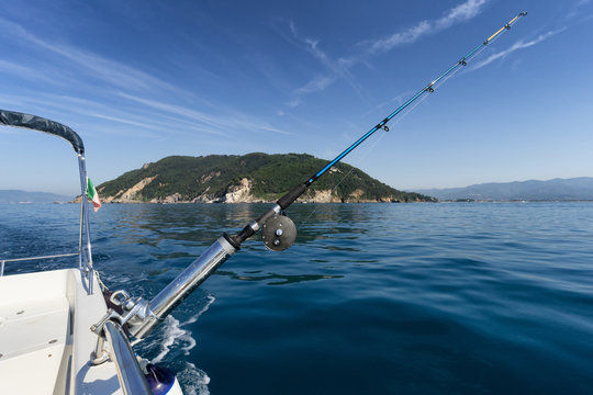 fishing rod on boat with island in background