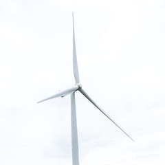 wind turbine in wind farm against cloudy sky