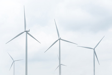 wind turbine in wind farm against cloudy sky