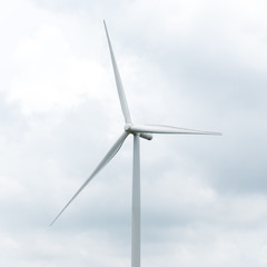 wind turbine in wind farm against cloudy sky